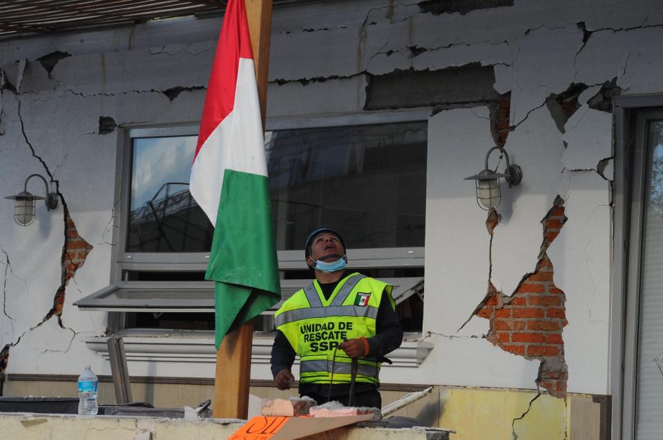  An emergency worker stands next to the destroyed school's walls