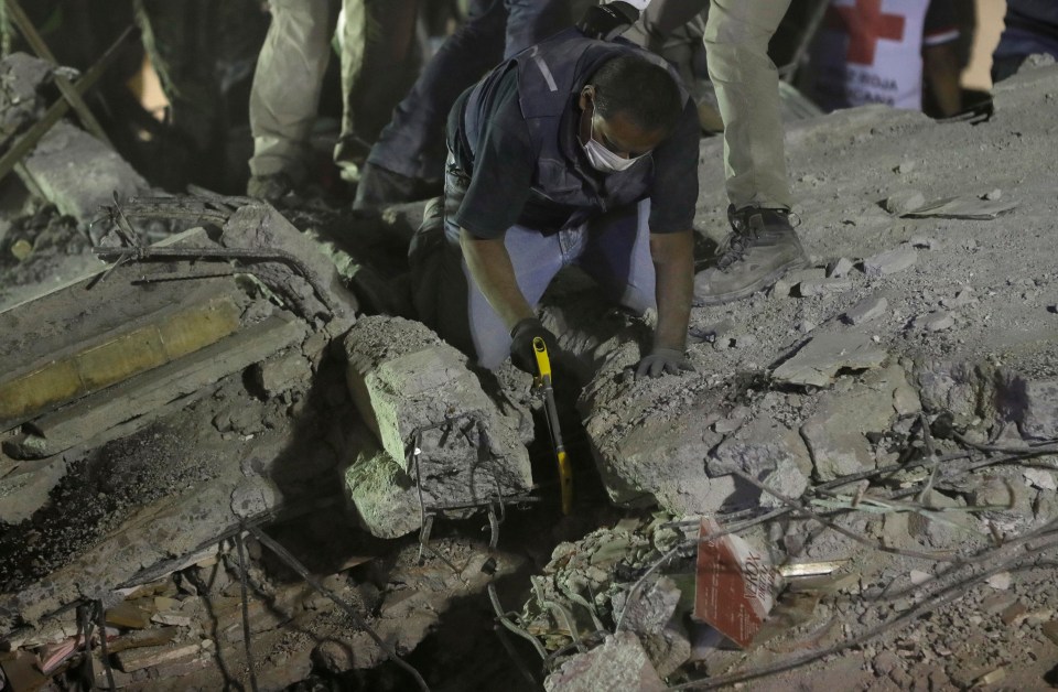 Rescue personnel work to free people trapped in the rubble