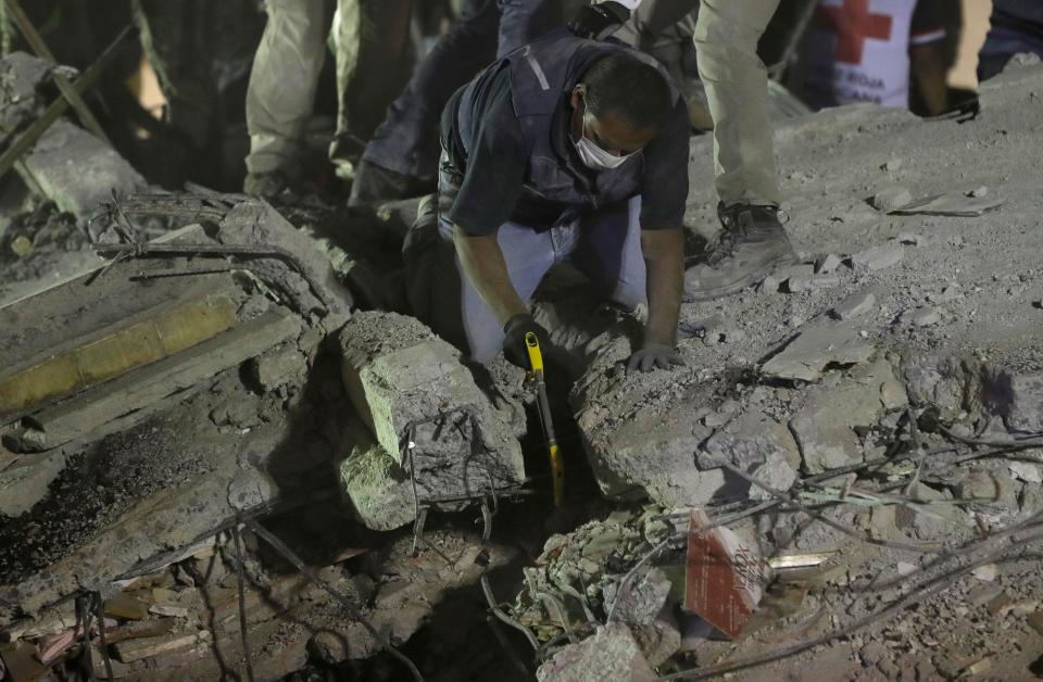  Rescue personnel work to free people trapped in the rubble