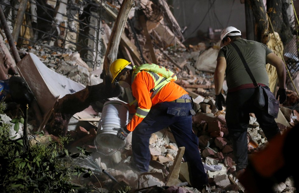 A rescue worker sifts his way through the rubble