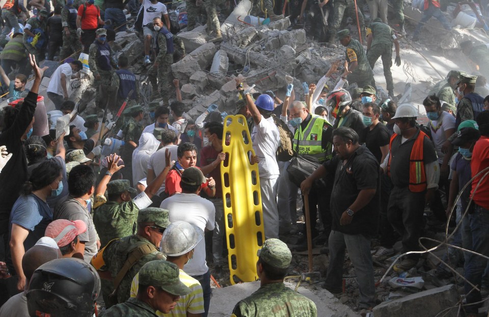 Rescuers go to the aid of a potential survivor buried in the rubble 