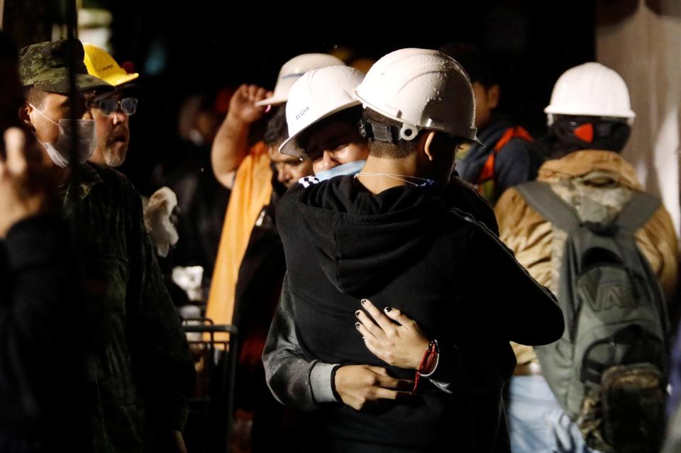  People helping with the rescue efforts embraced as they fought to find people alive in the rubble