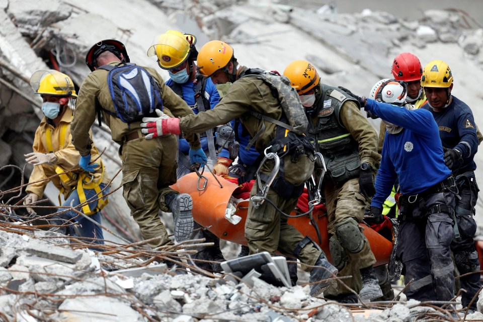 Rescuers begin the grim task of pulling out bodies from the rubble