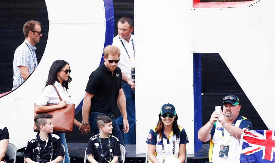  Prince Harry was quick to grab his girlfriend's hand as they left the match