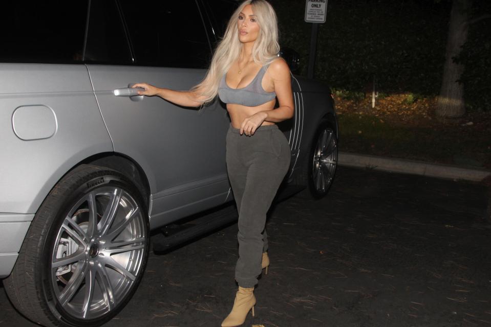  A grumpy-looking Kim Kardashian heads out of her car for dinner