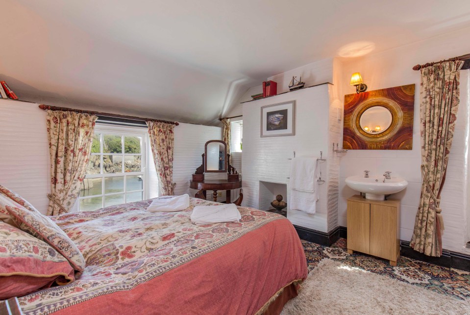 Bedroom in Willy Wilcox Cottage has a sink and towel rack. The room is quite large and can accommodate a double bed along with a stunning view.