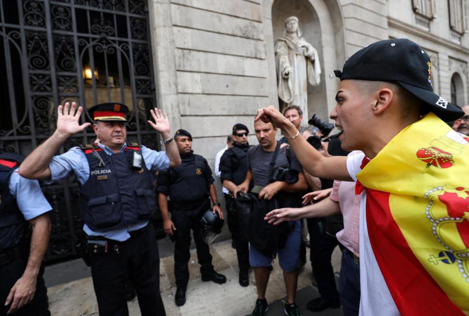  A demonstrator shouts at a Catalan regional policeman, in front of city hall