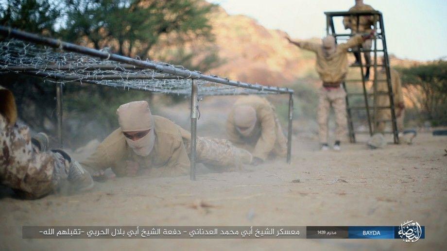 The jihadi trainees crawl under barbed wire during an assault course