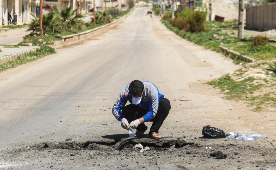  An investigator collects samples from the area the chemical device exploded