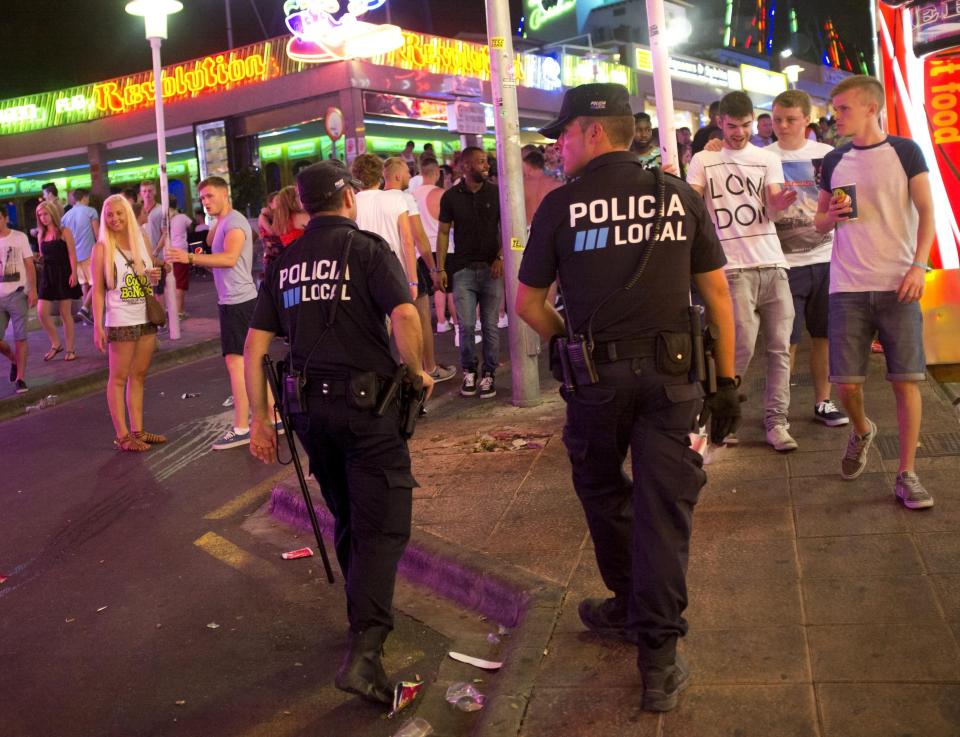  Two local cops patrol Punta Ballena party strip in Magaluf, Spain