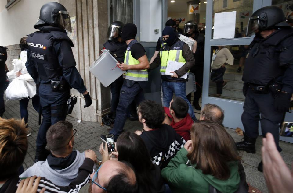  Cops walking away with ballot boxes after raiding a polling station in Barcelona