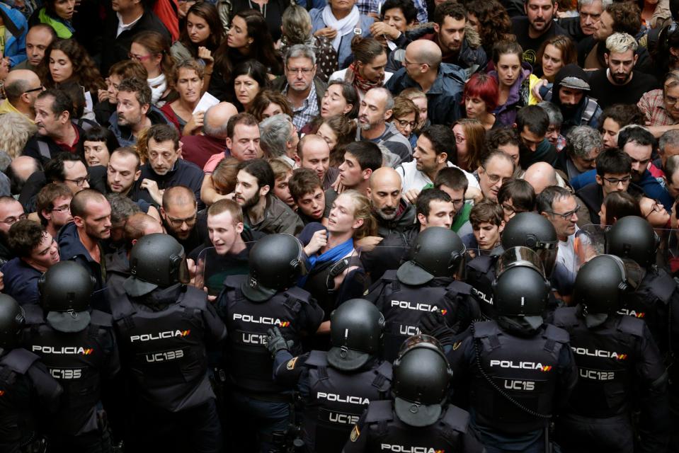  Spanish police holding back voters from a polling station at the Ramon Llull school in Barcelona