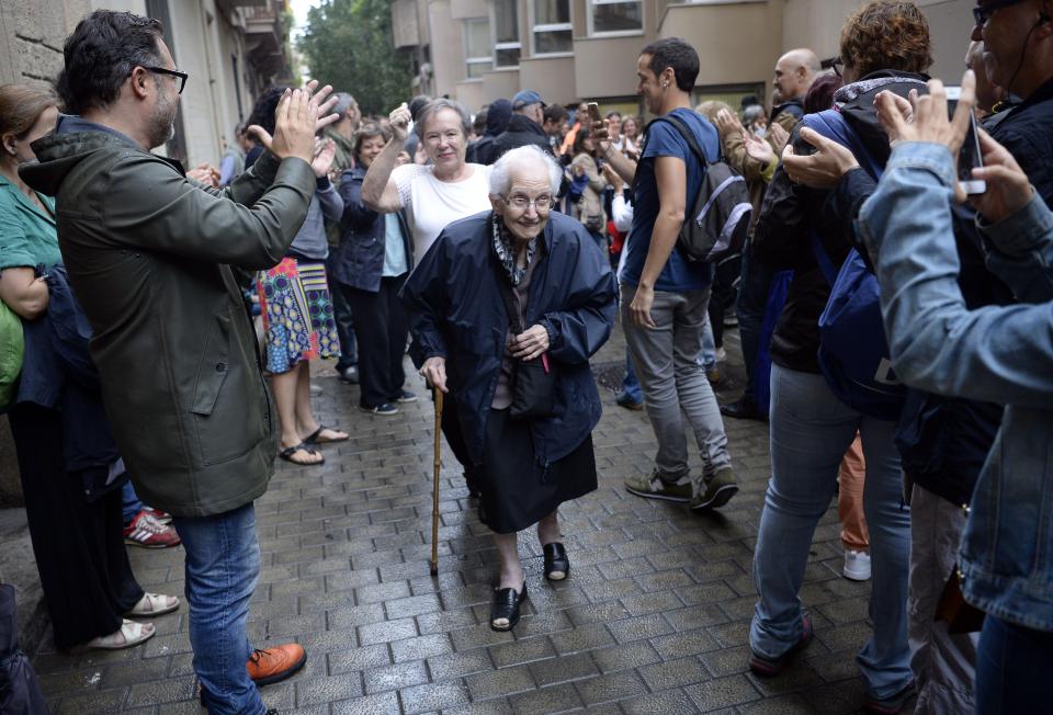  Catalonians applauding their fellow citizens who cast their votes in Barcelona this morning