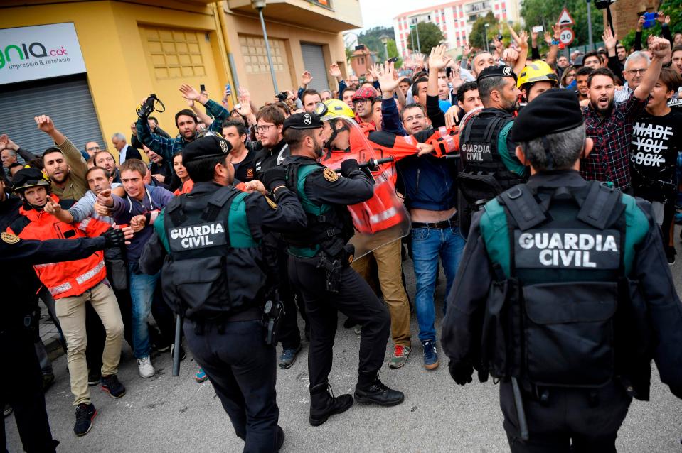  Catalan fire fighters try to keep protesters and the national police separated