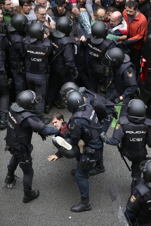  A protester is surrounded by riot police during the chaos in Catalonia