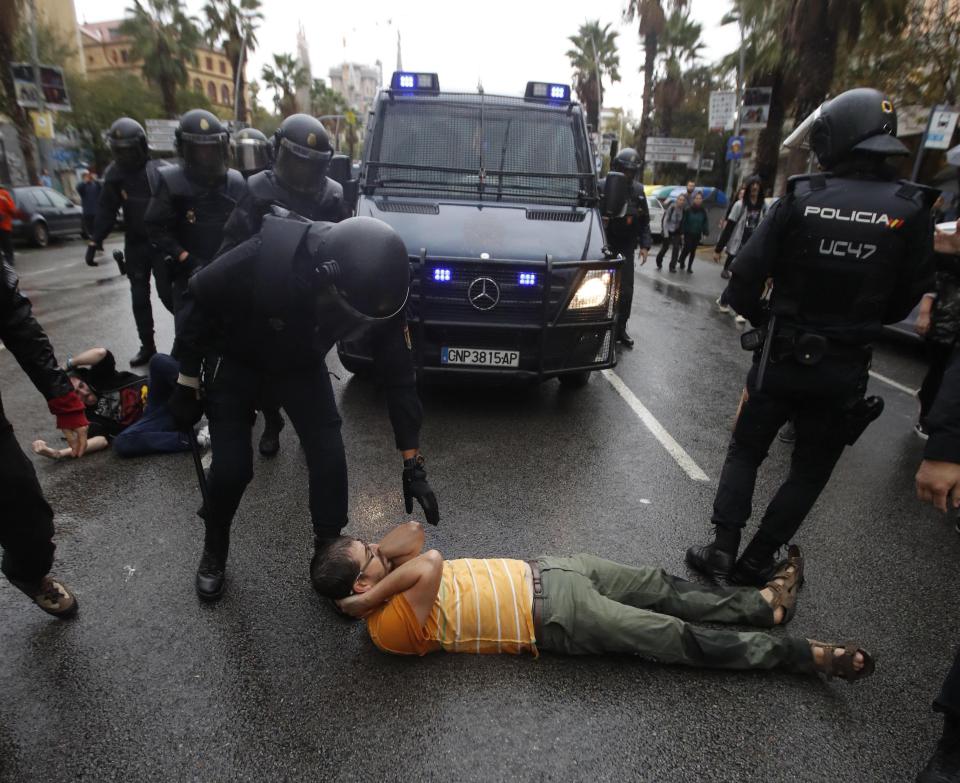  Police detain a man during the Catalan independence day vote