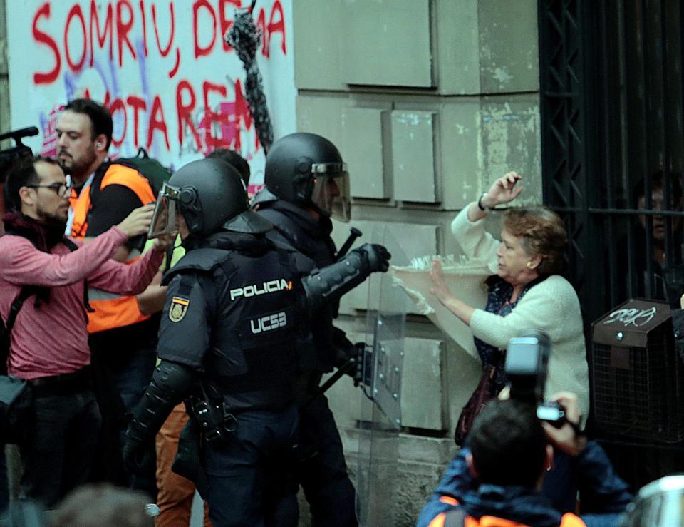  A cop grabs at a woman's clothes during ugly scenes in Catalonia today