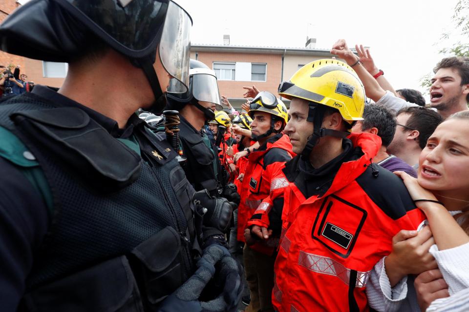  Catalan firefighters form a chain to protect protesters from riot cops