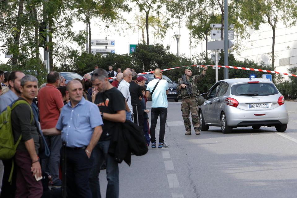  Passengers who were rushed out of the station look on as the scene unfolds