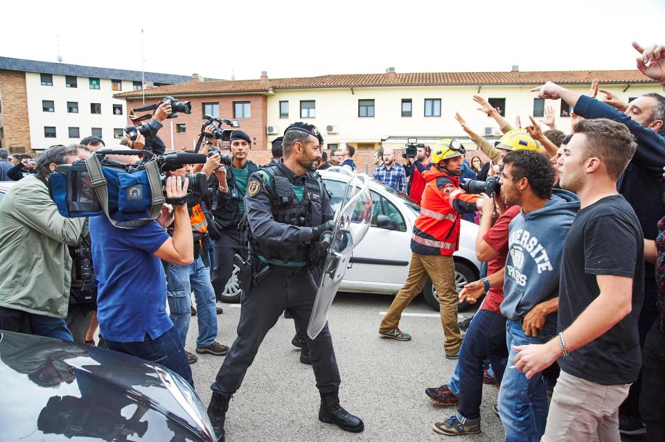  Firefighters can be seen urging protesters back away from police