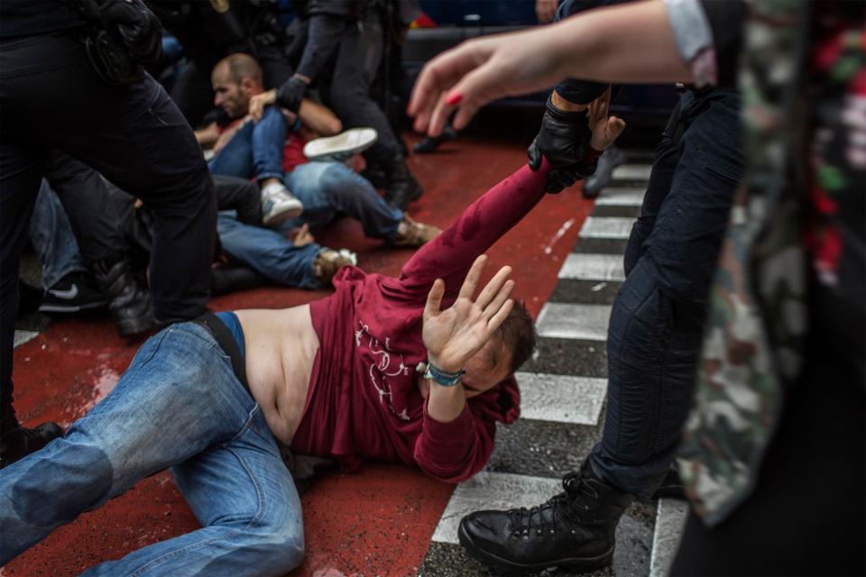  A demonstrator cowers on the floor amid clashes with police