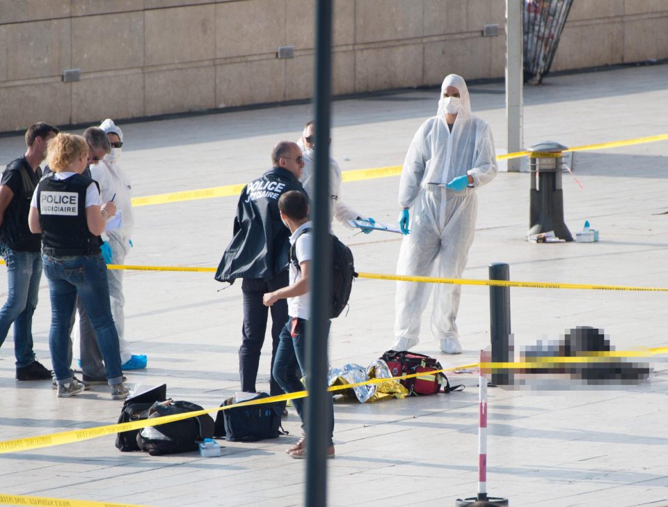  Police work through the cordoned crime scene near the body of one of the stabbing victims