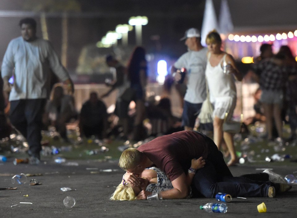 A man holds a woman injured in the horrific attack