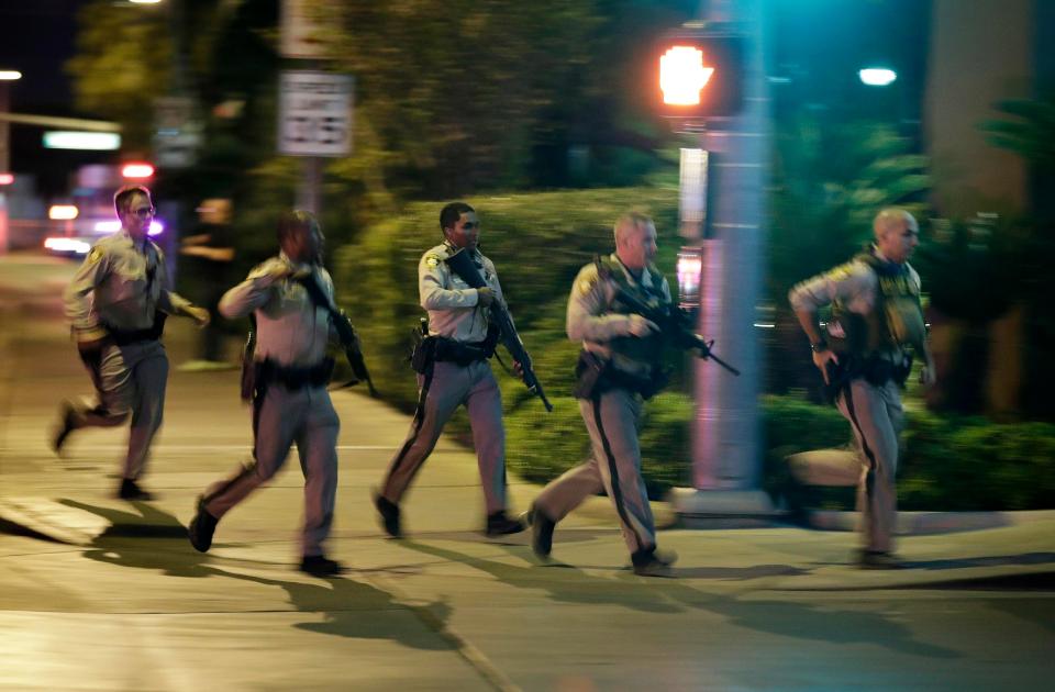  Police run to cover at the scene of a shooting near the Mandalay Bay resort