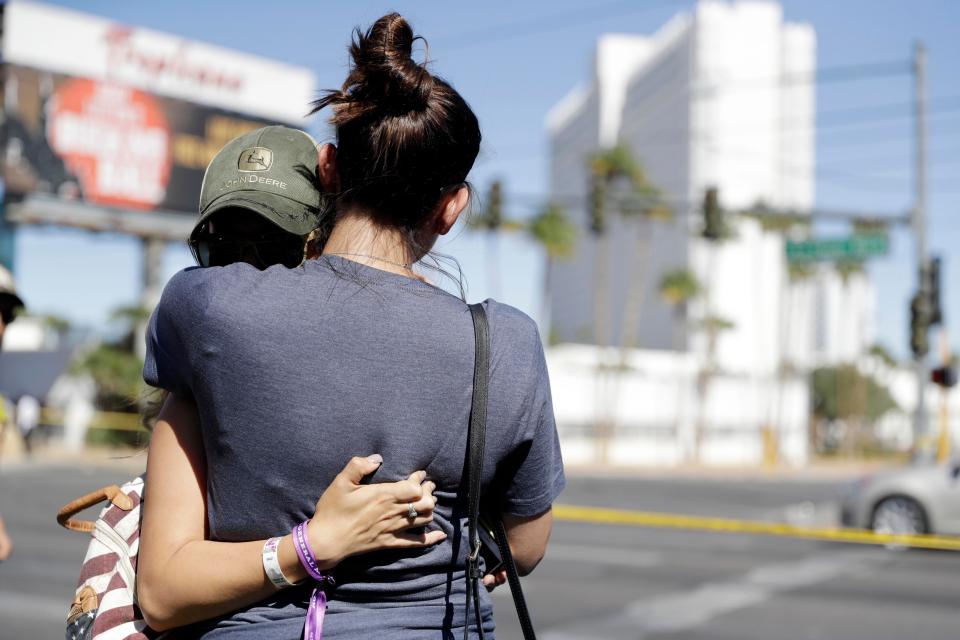  Concert-goers hug each other near the scene of the mass shooting