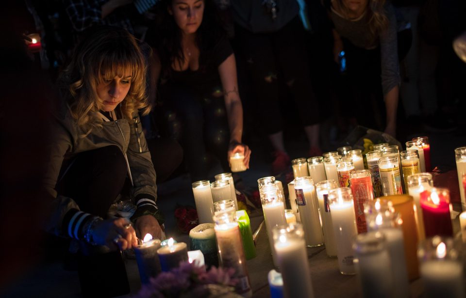  Mourners light candles during a vigil for those killed in the gun massacre