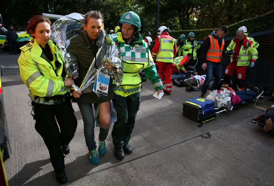 A casualty of the simulated attack is wrapped in a foil blanket by 999 crews