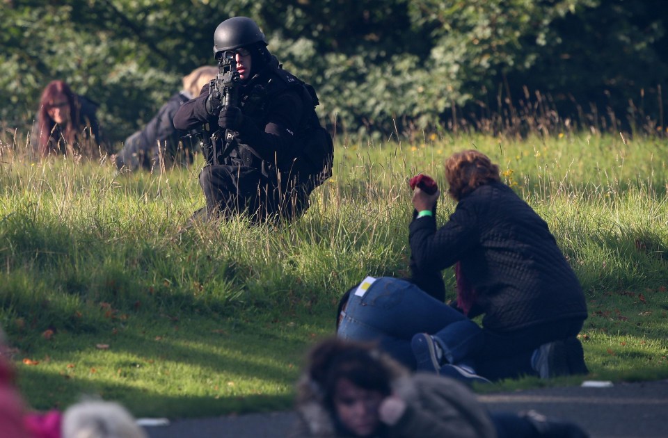 People cower in fear as armed cops take on marauding jihadis in a simulated terror attack today