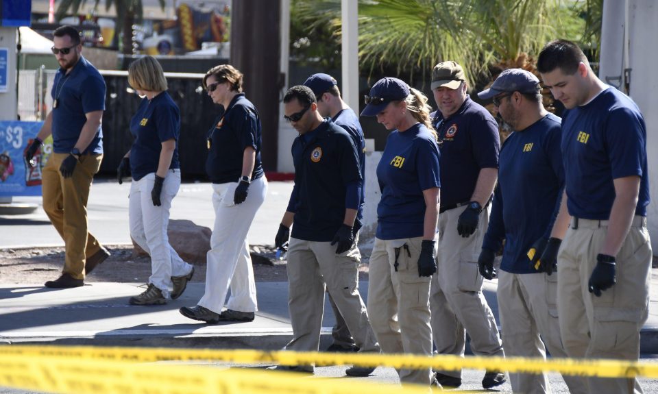  The FBI are seen sweeping the road for evidence after the gun massacre