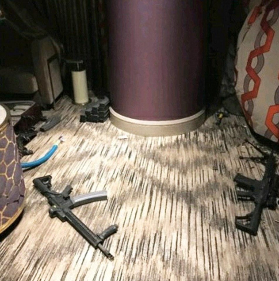 The room is littered with bullet casings and a terrifying arsenal of guns