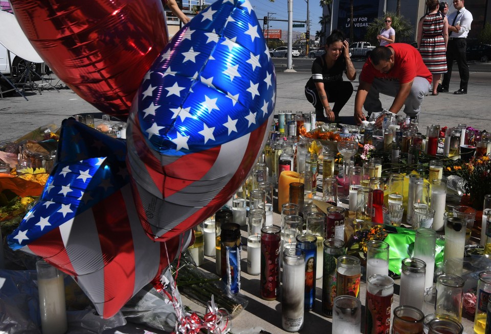 People light candles and pray at a makeshift memorial to the victims