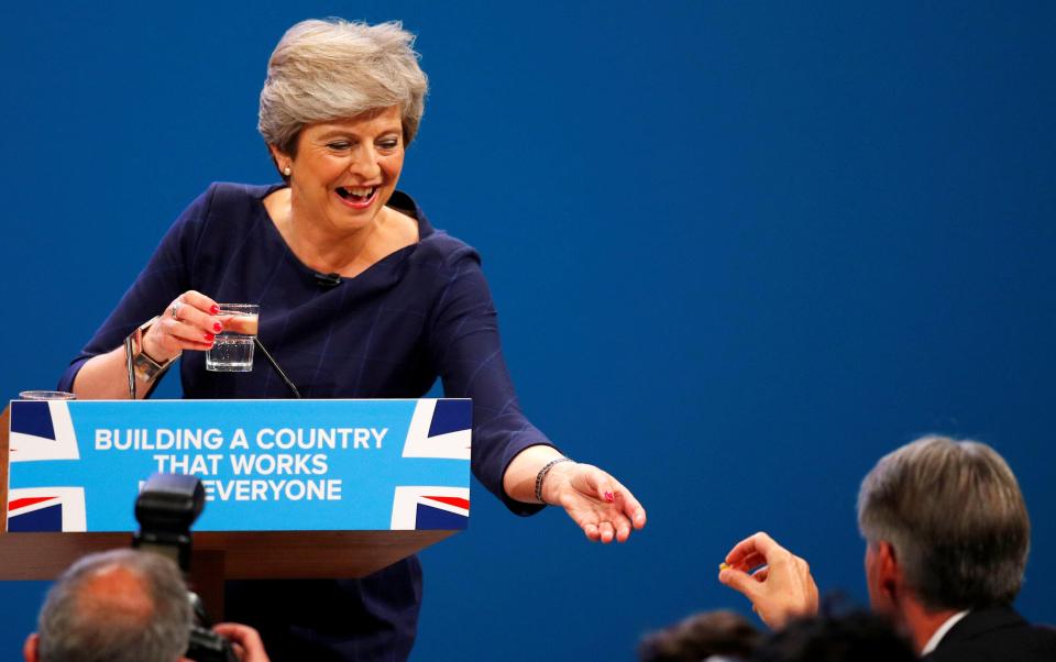  Chancellor Philip Hammond reached up to give her a cough drop to try and help her carry on