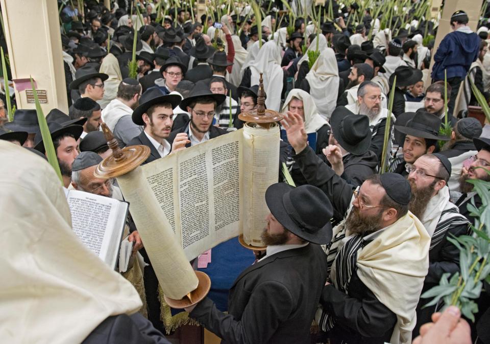  A Jewish man reads from the Torah during Sukkot services in Crown Heights, Brooklyn, New York