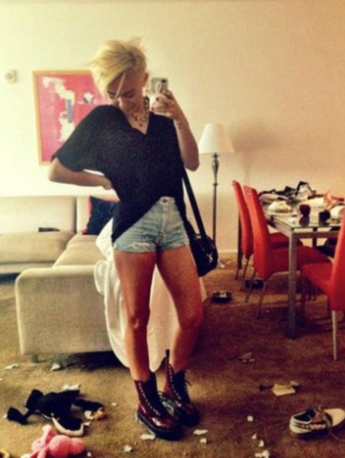  It's hard to tell if Miley Cyrus is looking at her boots or her filthy carpet