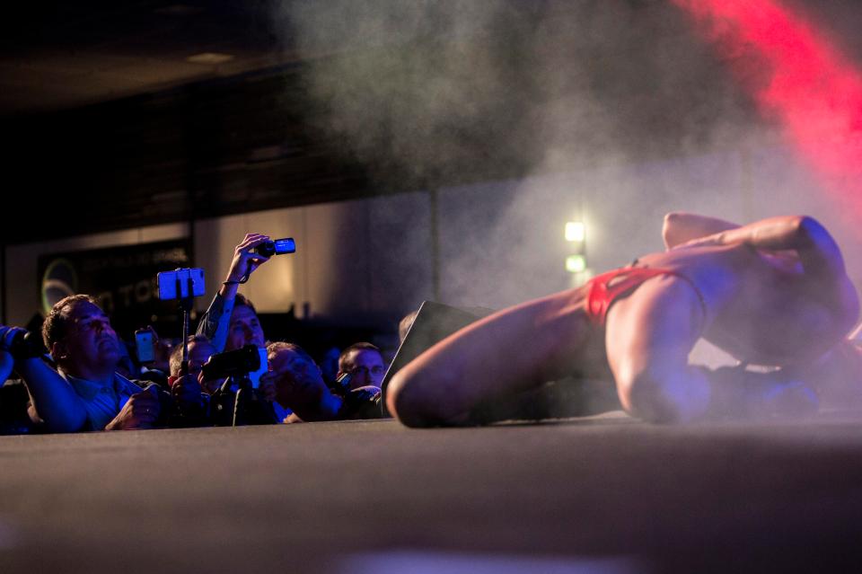  A dancer gyrates on the stage during the opening day of the event