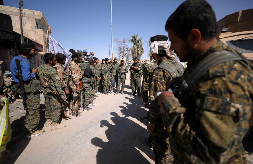  Militia men listen during a briefing at the front line in Raqqa