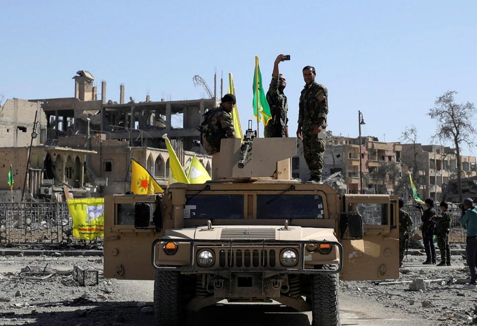  An SDF fighter takes a selfie as he stands on a military vehicle