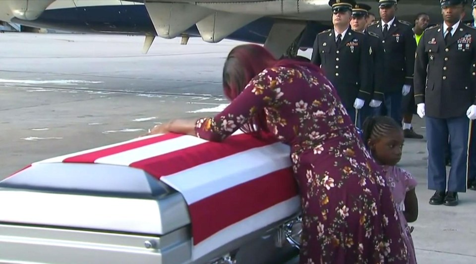 The soldier's widow cried over his flag-draped coffin as his body arrives back home 