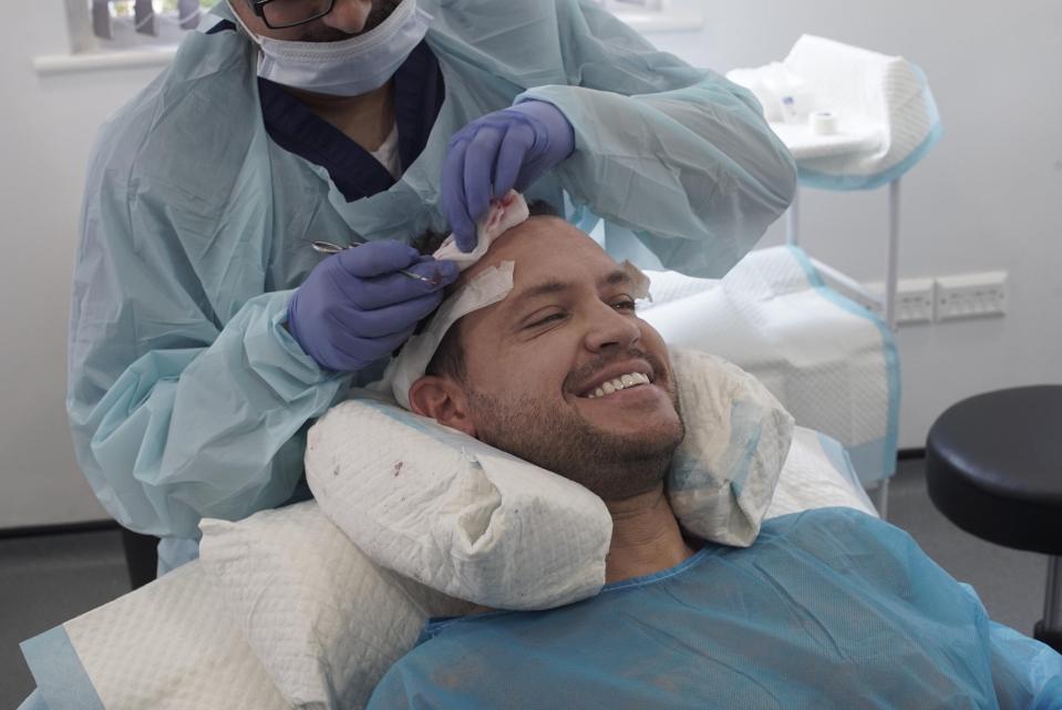  Jamie smiles as a male surgeon wipes his wounds