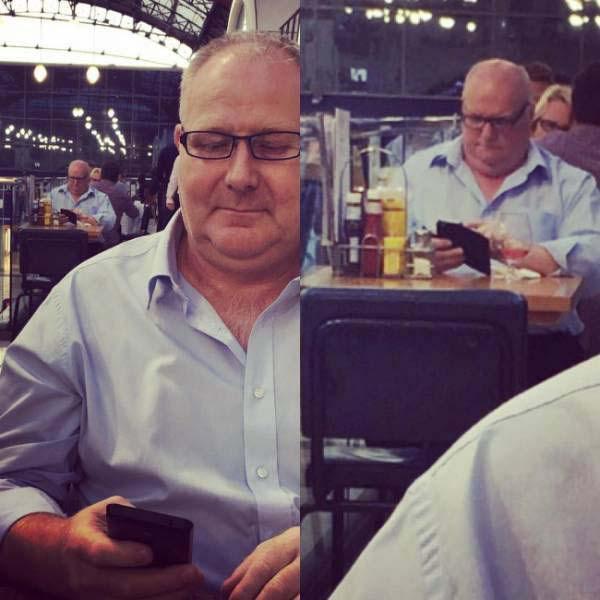  A pub-goer appears to have an identical replica of himself checking his phone in the background