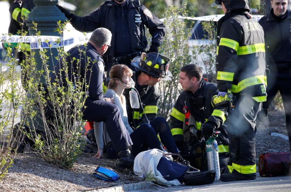 Paramedics tend to a woman at the side of the street after people were mowed down by a truck in New York