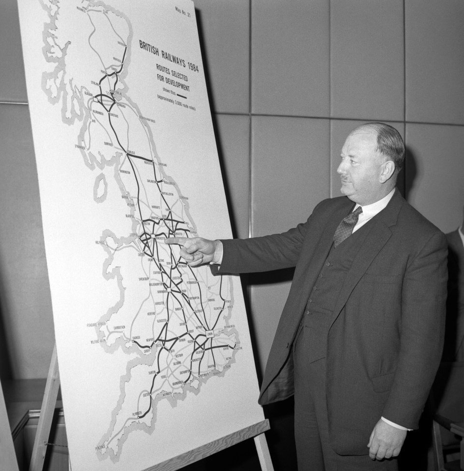  Dr Richard Beeching, pictured in 1964, points out details on a large map, showing how British Rail trunk routes may look after his cuts