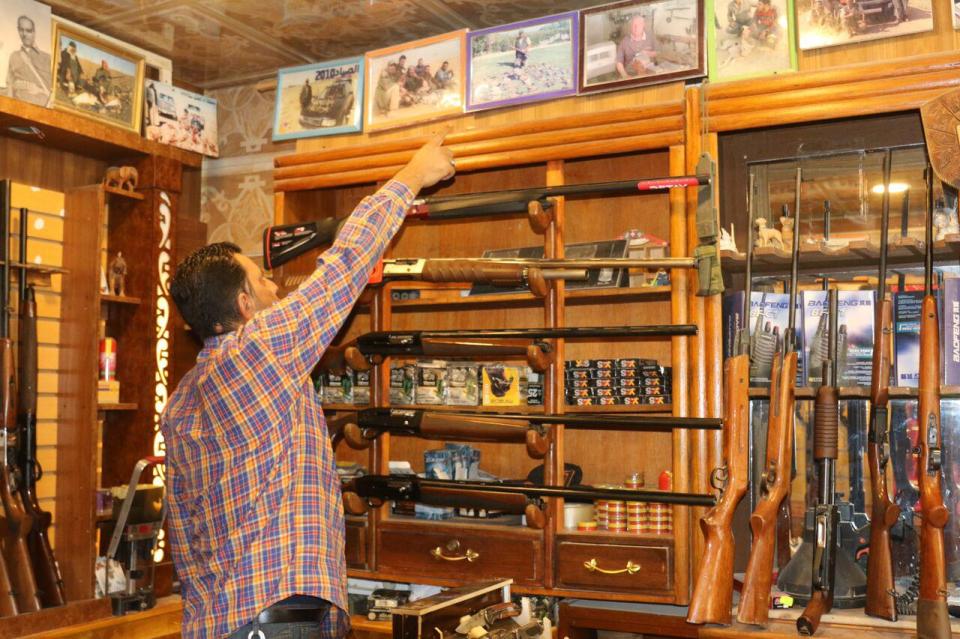  The bereaved dad points to photos in his gun shop