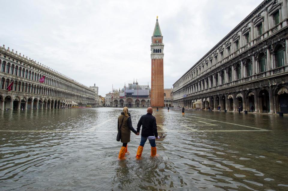  A couple walk through a flooded Saint Mark's Square in Venice in 2013