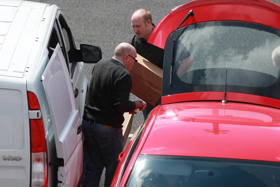  HMRC officers bundle documents into their vans during raids