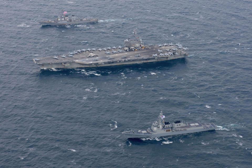  The USS Ronald Reagan flanked by two Arleigh Burke-class destroyers